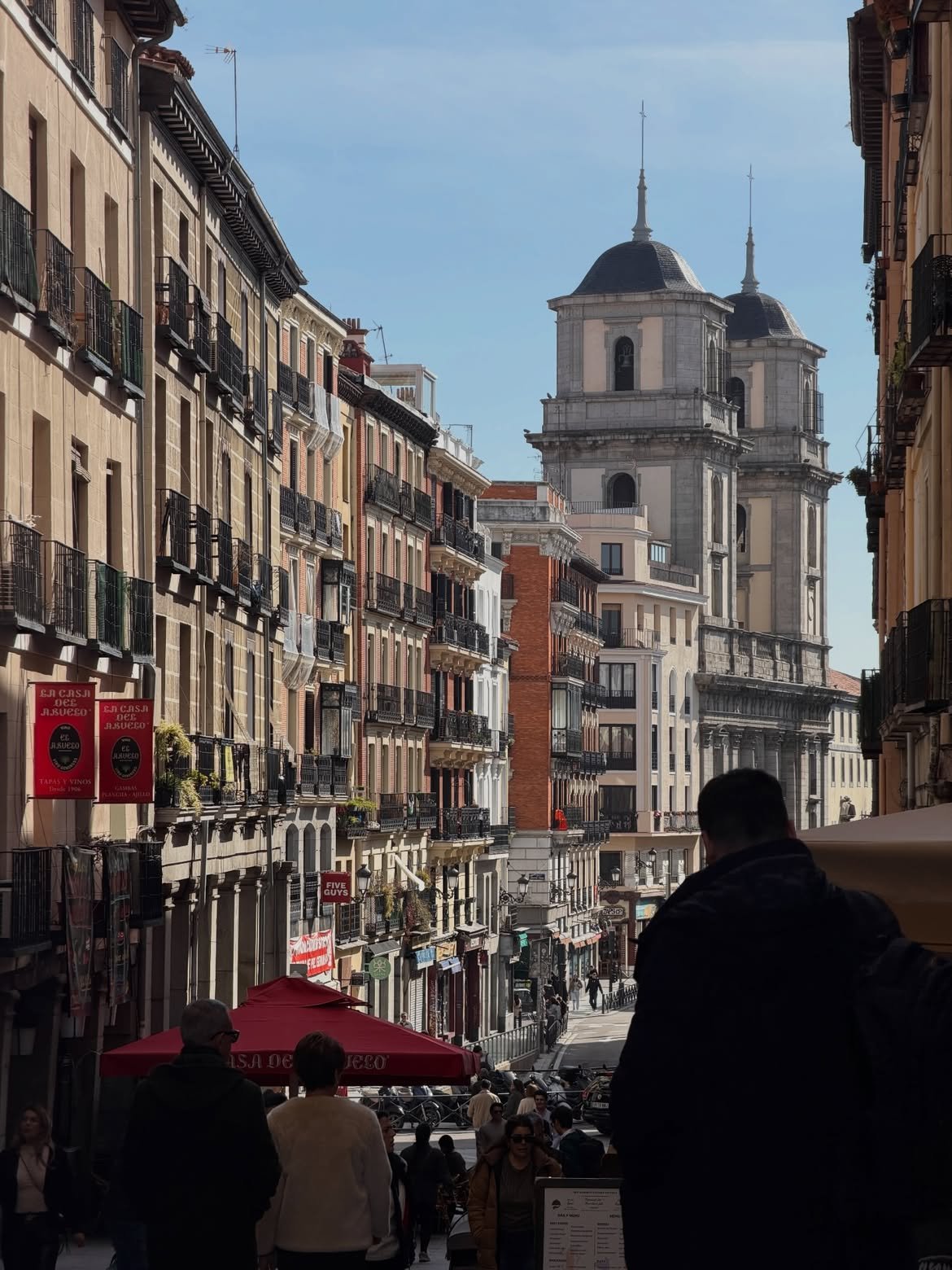 Madrid street with balconies and twin church towers