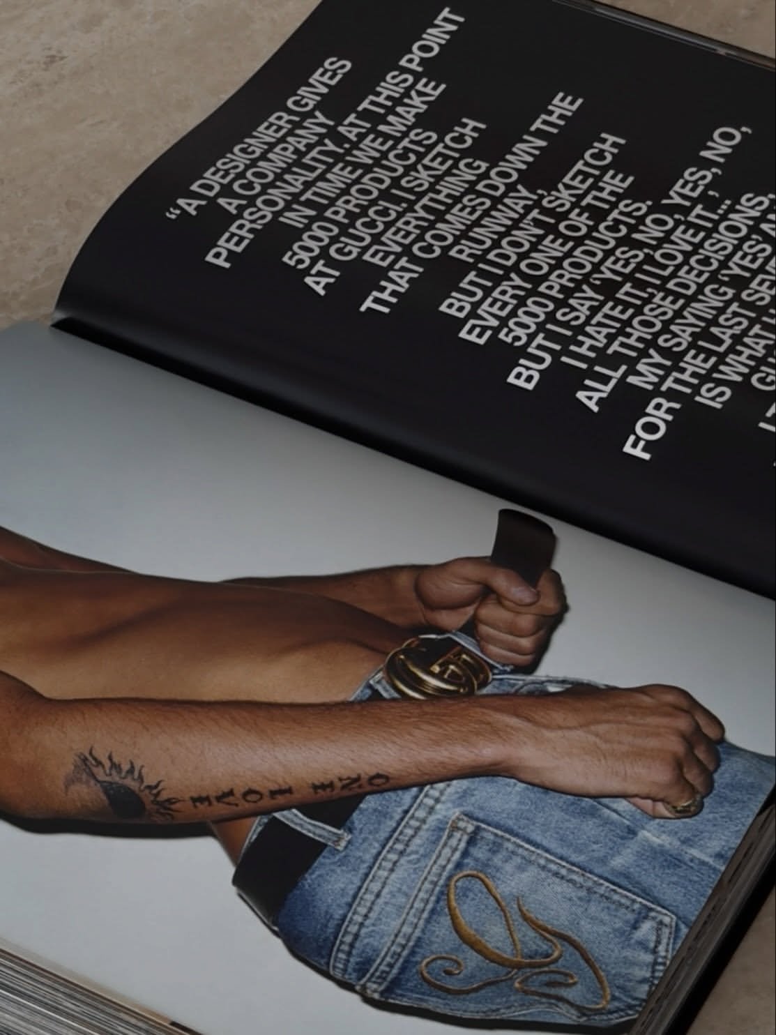 Open magazine spread with a Gucci denim image and a quote